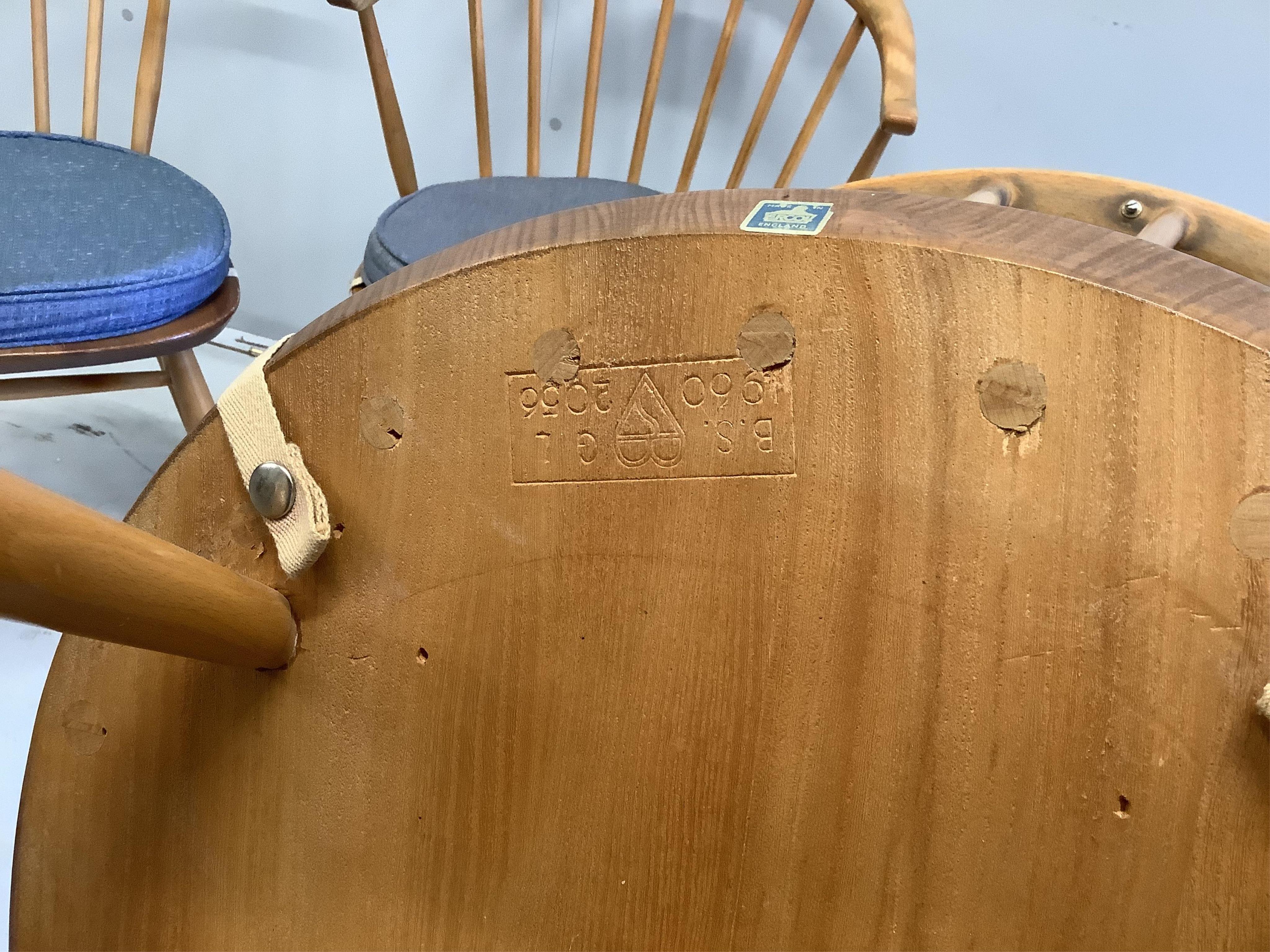 An Ercol circular elm and beech drop flap dining table, diameter 112cm, height 71cm, and four Ercol chairs. Condition - fair